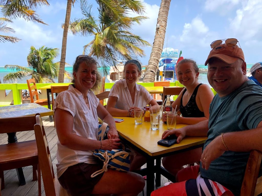 Laura Rahn sitting with her family and a beachy sea view in the background
